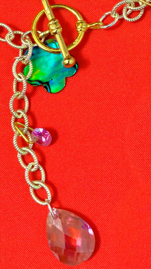 Close up photo of gold vermeil toggle clasp and pink cubic zirconia on sterling silver chain